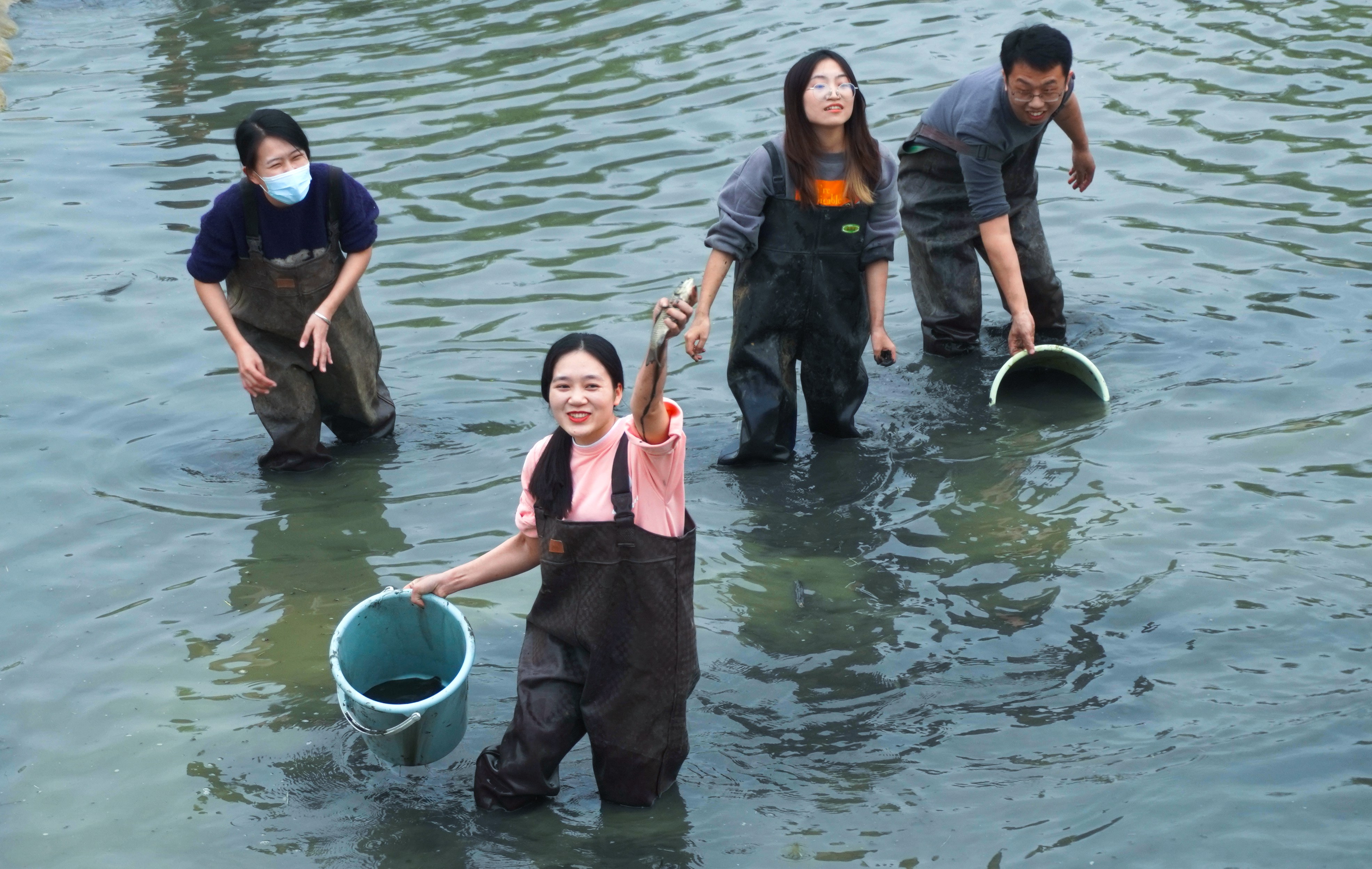 学生在浑水中摸到鱼时的欢快(永利集团88304官网记者 徐震 摄)